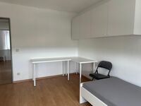 Zimmer mit Arbeitstisch und Bett