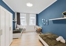 Schlafzimmer 2 mit zwei Einzelbetten, Schränken und Arbeitsplatz