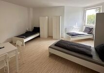 3-Bett Zimmer mit TV und Esstisch