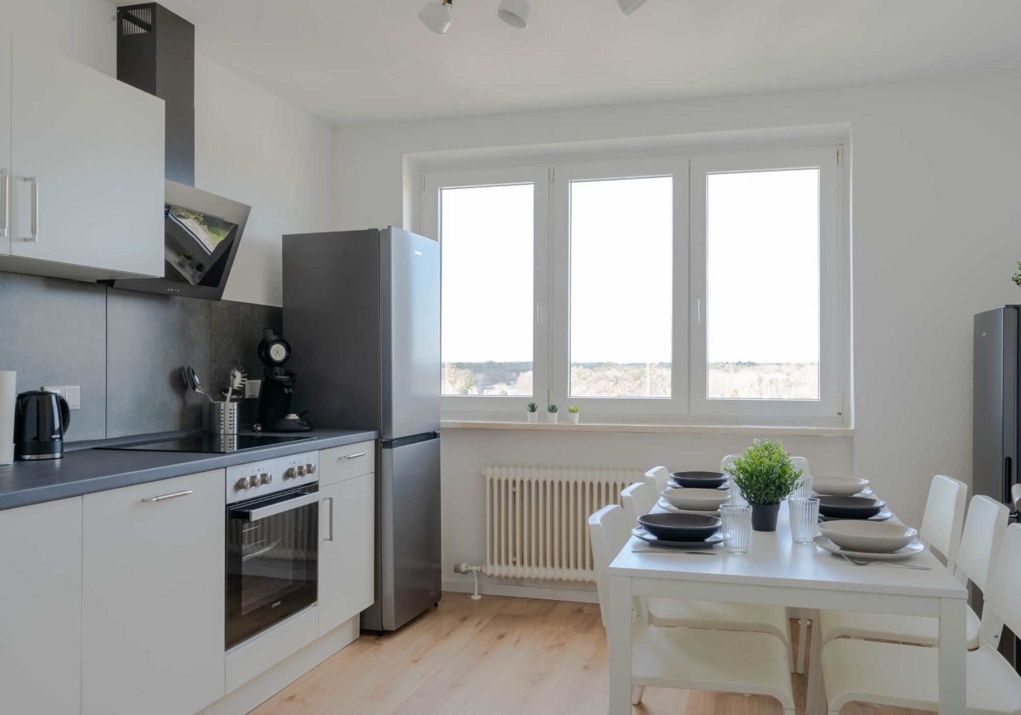 Küche mit Esstisch und großem Kühlschrank