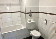 Badezimmer mit Badewanne mit WC