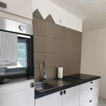 Küchenzeile mit Elektrogeräten, Kühlschrank, Kaffemaschine, Wasserkocher, Geschirr und Esstisch 