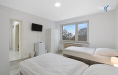 Schlafzimmer 2 mit zwei Einzelbetten, Sitzecke und Smart TV