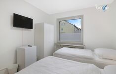 Schlafzimmer 3 mit zwei Einzelbetten, Sitzecke und Smart TV