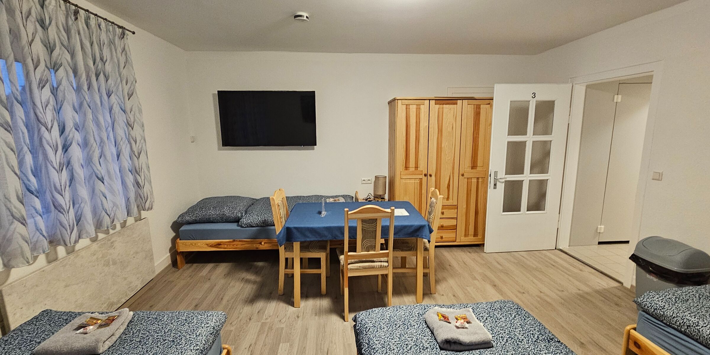 4 Bett Zimmer mit großem Fernseher.