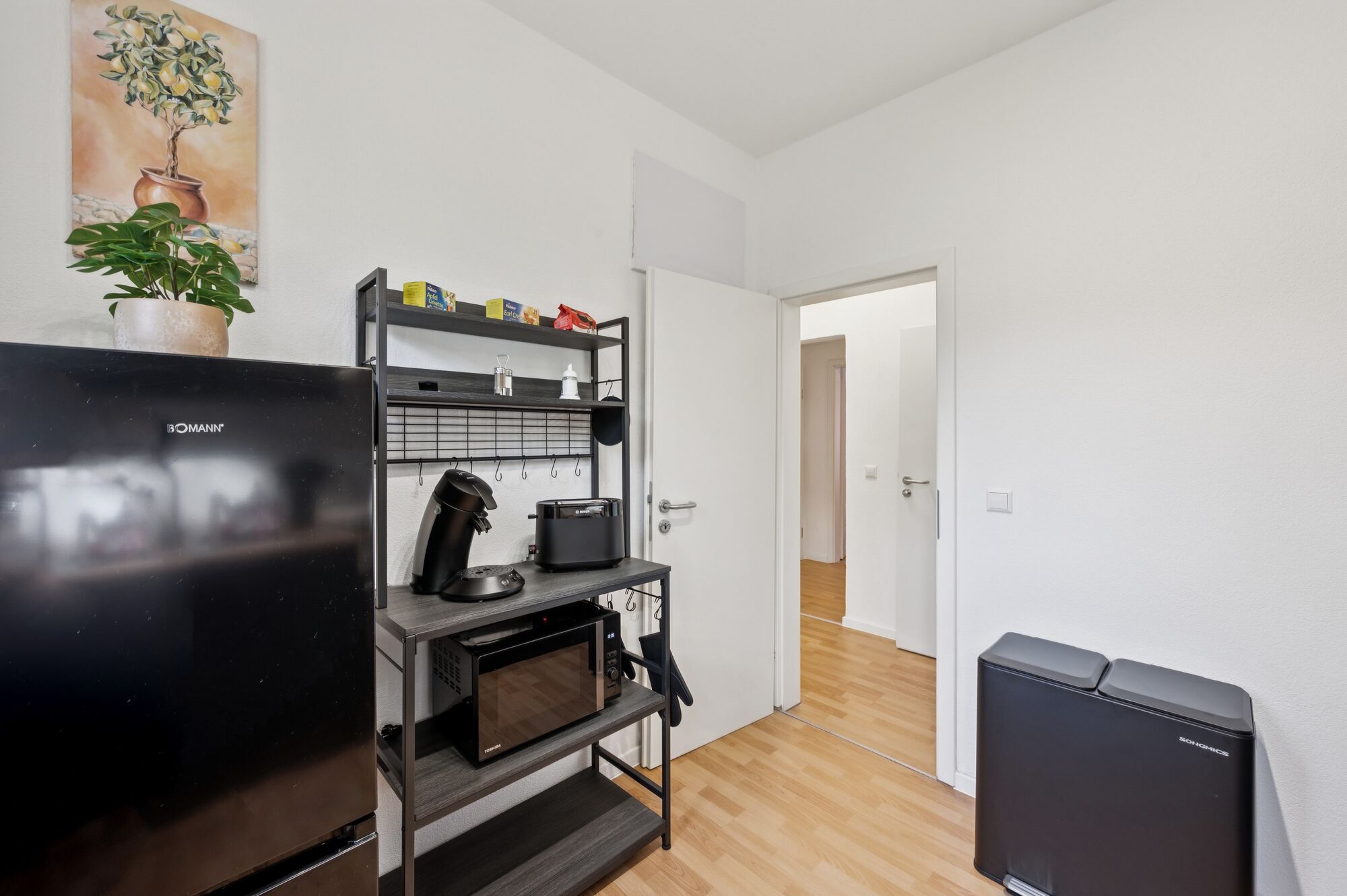 Voll ausgestattete, moderne Küche mit Kaffeemaschine, Toaster, Mikrowelle und großem Kühlschrank.