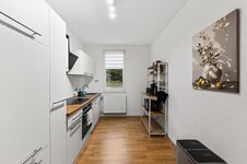 Wohnung 1: Große, voll ausgestattete Küche mit Herd, Backofen, Mikrowelle und viel Platz zum Kochen.