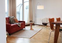 Wohnzimmer mit Schlafsofa, Galerie, bodentiefen Fenstern und Parkett