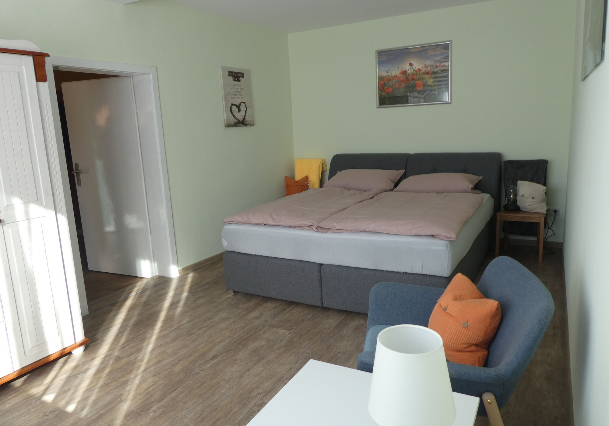 Schlafzimmer mit Boxspringbett, Sitzgelegenheit, TV, Außenrollo