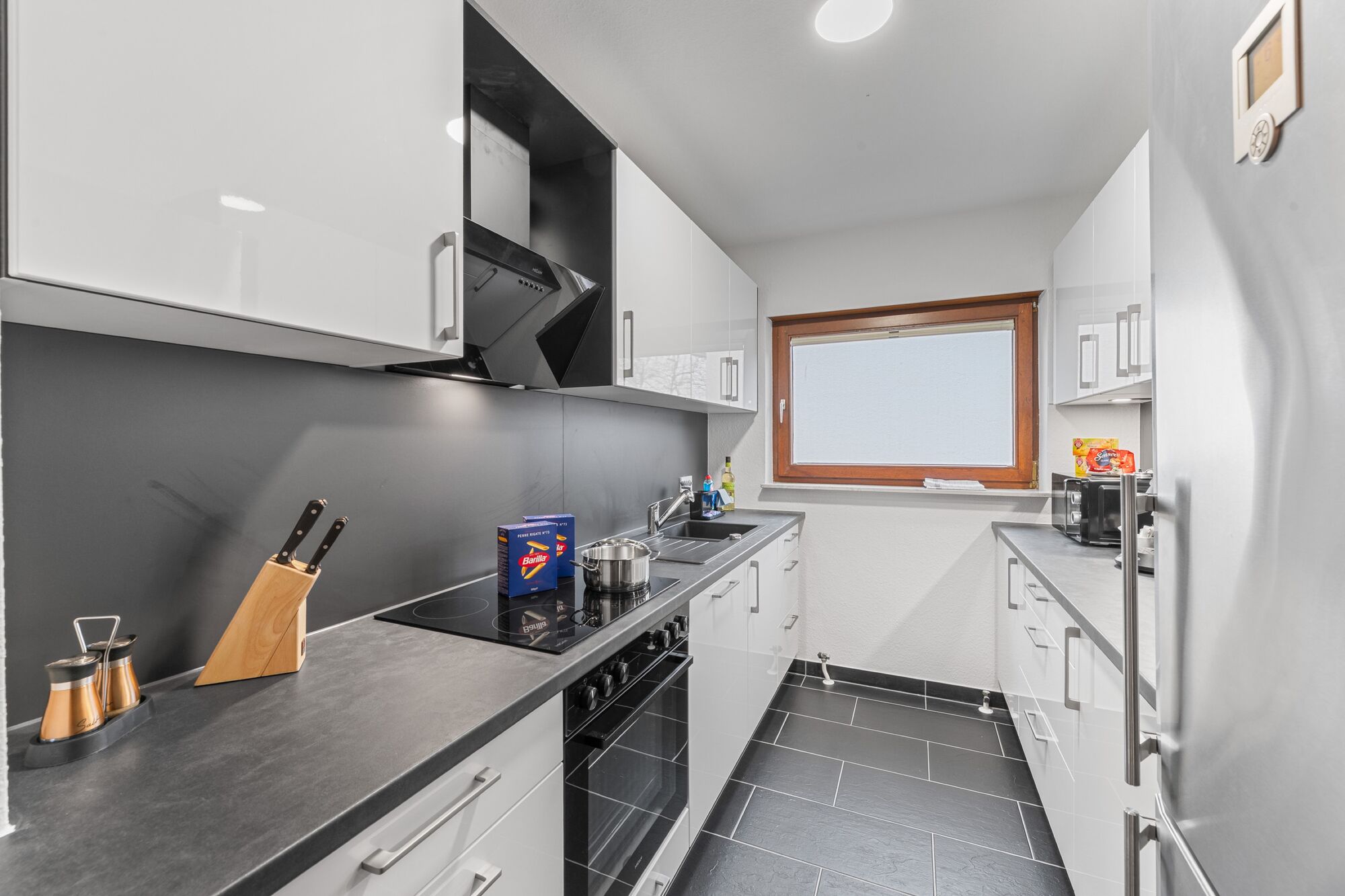 Voll ausgestattete Küche mit Herd, Backofen, sehr großem Kühlschrank und Arbeitsfläche.