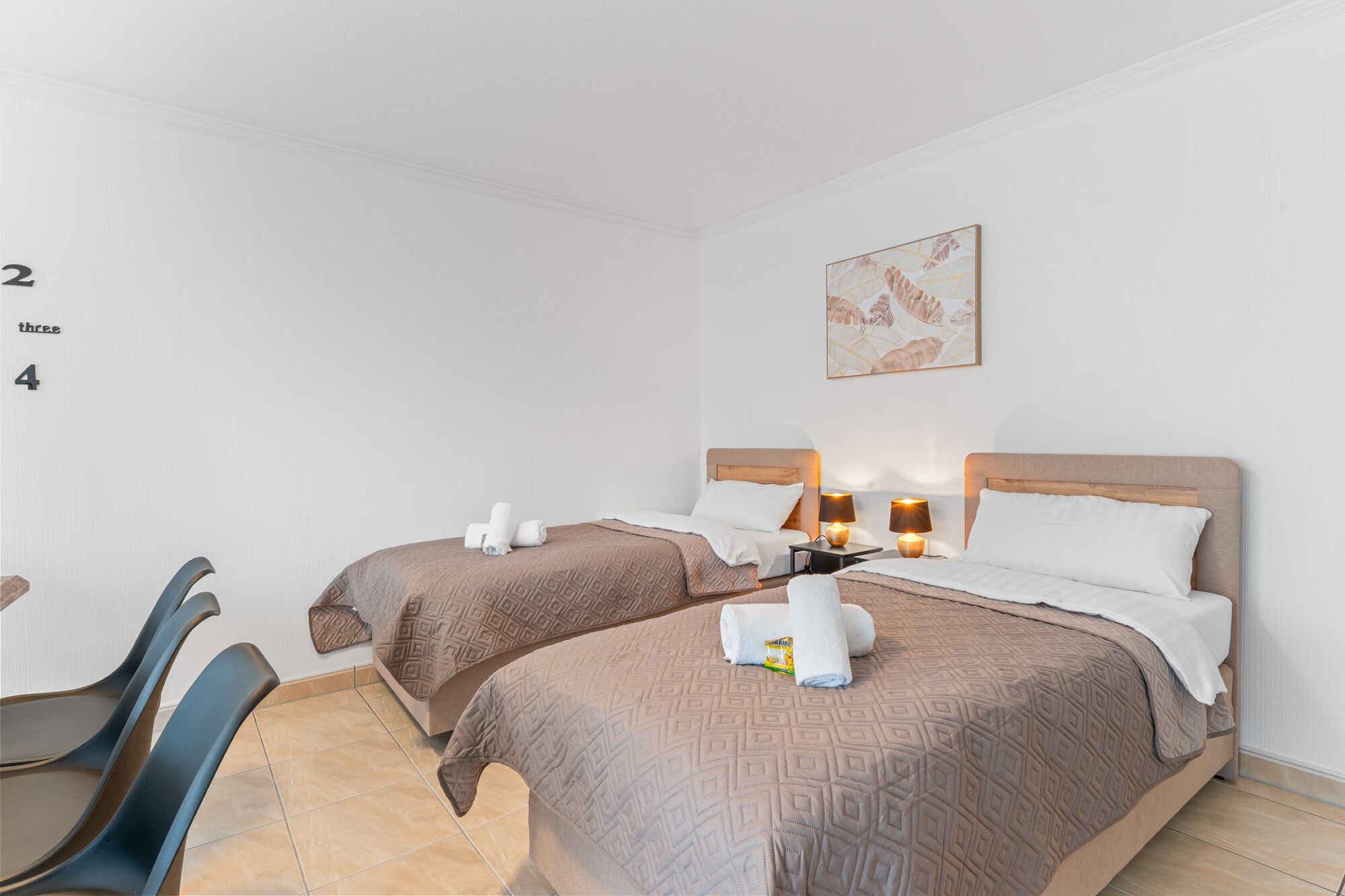 Wohnzimmer mit zwei hochwertigen Boxspringbetten und einem gemütlichen Essbereich. Die Betten können wahlweise einzeln oder als komfortables Doppelbett gestellt werden.