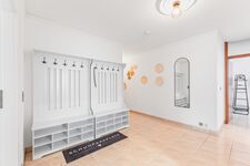 Großer Flur mit großer Garderobe, Schuhablage und Spiegel.