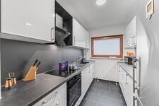 Voll ausgestattete Küche mit Herd, Backofen, sehr großem Kühlschrank und Arbeitsfläche.