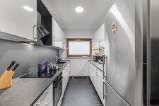 Voll ausgestattete Küche mit Herd, Backofen, sehr großem Kühlschrank und Arbeitsfläche.