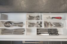 Komplett ausgestattete Küche mit Besteck und Küchenutensilien.