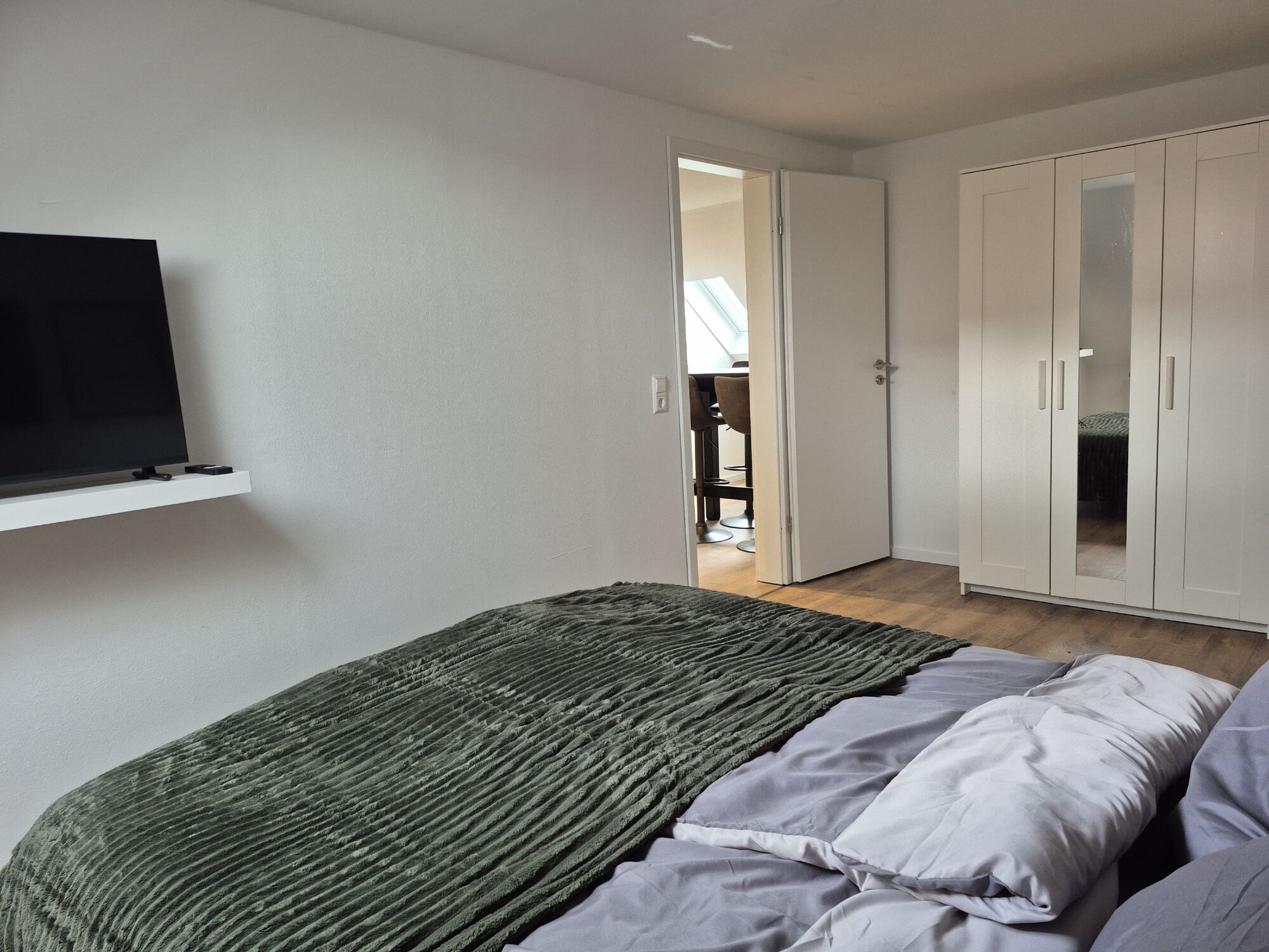 Schlafzimmer mit Doppelbett, TV und Kleiderschrank