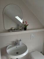 Badezimmer mit Waschmaschine und Badewanne 