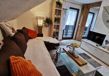 Gemütliches Wohnzimmer mit LED - SAT - TV, Couch und direktem Zugang zur Küche und Balkon