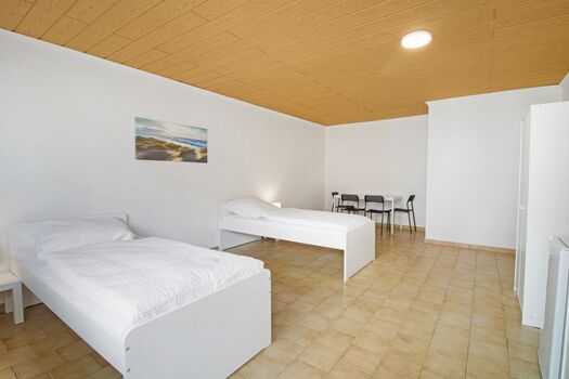 Schlafzimmer 1 mit zwei Einzelbetten, Sitzecke und Smart TV