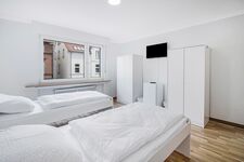 Schlafzimmer 2 mit drei Einzelbetten, Sitzecke und Smart TV