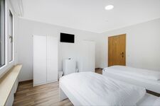 Schlafzimmer 2 mit drei Einzelbetten, Sitzecke und Smart TV