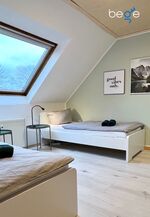 Schlafzimmer 1 mit zwei Einzelbetten, Sitzecke und Smart TV 