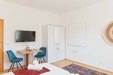 3-Zimmer-Wohnung: Zimmer 3 – Helles Zimmer mit zwei Einzelbetten. Ausgestattet mit 40 Zoll Smart-TV, Schreibtisch, Stuhl und Stauraum. Große Fenster sorgen für viel Tageslicht.
