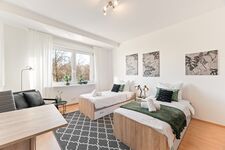 3-Zimmer-Wohnung: Zimmer 2 – Helles Zimmer mit zwei Einzelbetten. Ausgestattet mit 40 Zoll Smart-TV, Schreibtisch, Stuhl und Stauraum. Große Fenster sorgen für viel Tageslicht.