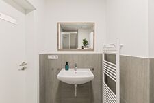 4-Zimmer-Wohnung: Neues Badezimmer Modern ausgestattetes Badezimmer mit Dusche, WC und Waschbecken. Helle Fliesen und funktionale Ausstattung.