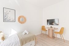 4-Zimmer-Wohnung: Zimmer 4 - Helles Zweibettzimmer mit zwei Einzelbetten. Ausgestattet mit Nachttischen, Tisch, Stuhl und 40 Zoll Smart-TV. Große Fenster sorgen für viel Tageslicht.
