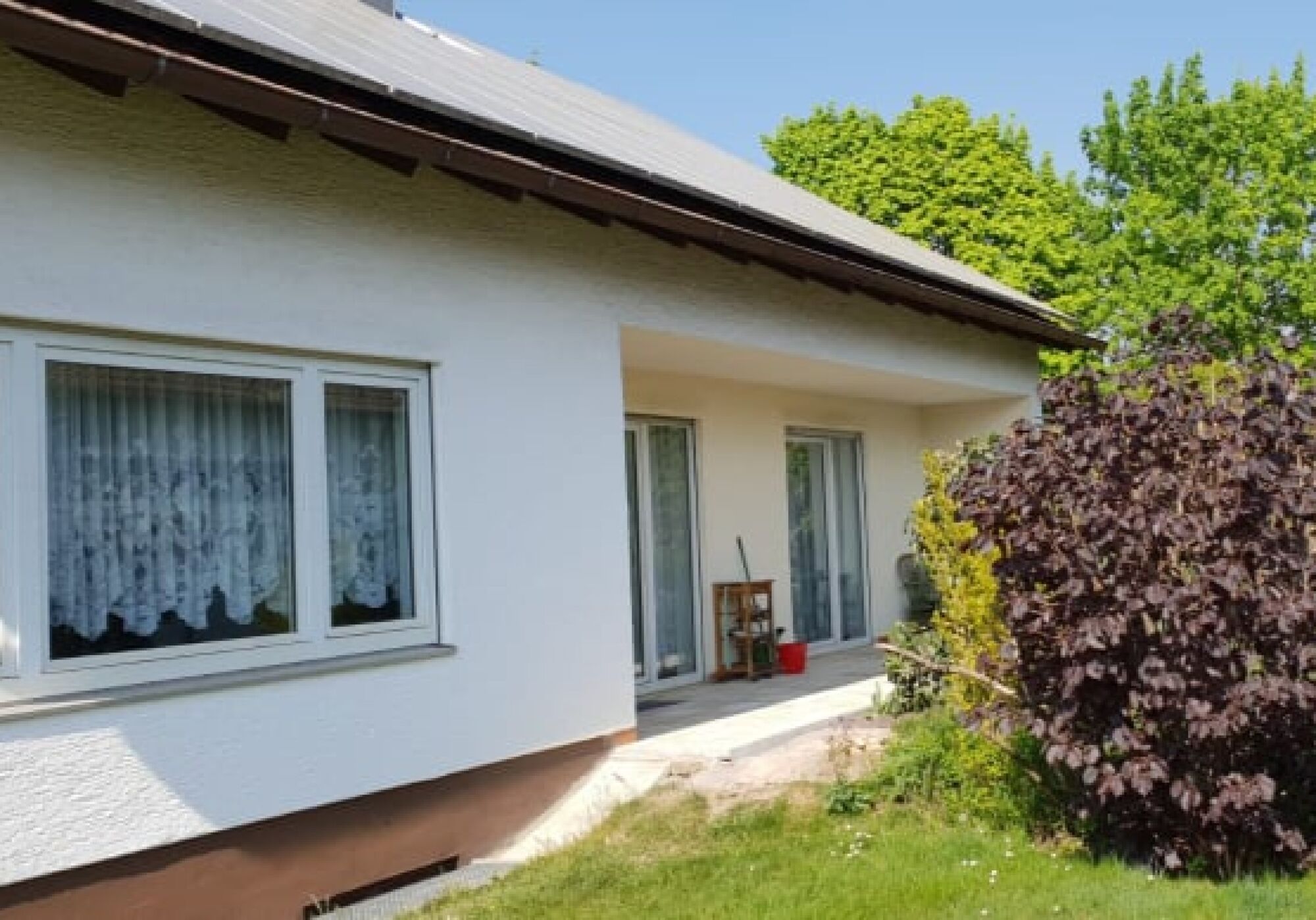 Süd-Ansicht und Terrasse - Hinter den Büschen ist noch ein großer Gartenbereich zum grillen